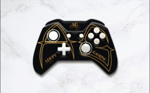 A black and gold controller with the words adopt gaming on it.