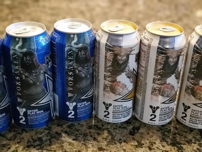 Four cans of energy drinks are sitting on a counter.