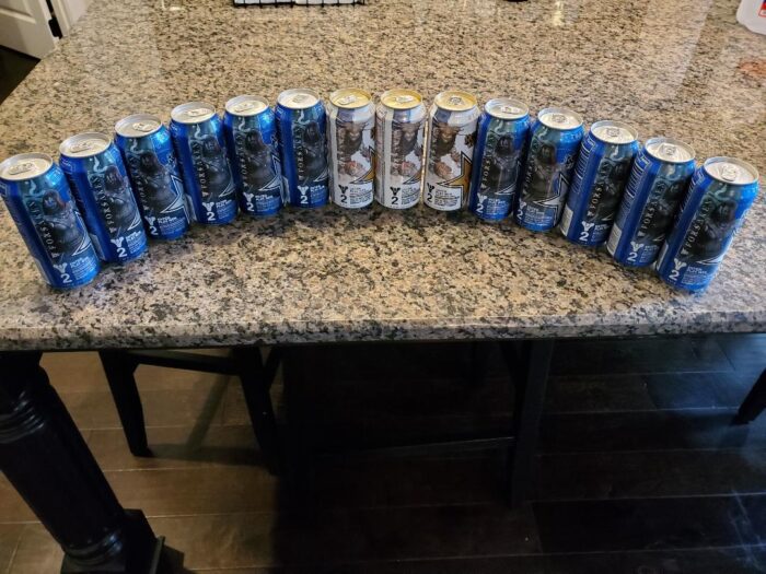 A counter with many cans of energy drinks on it