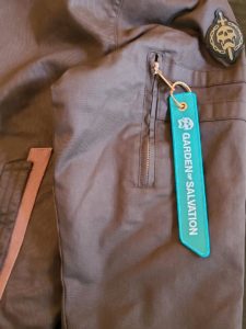 A blue tag hanging from the side of a brown jacket.